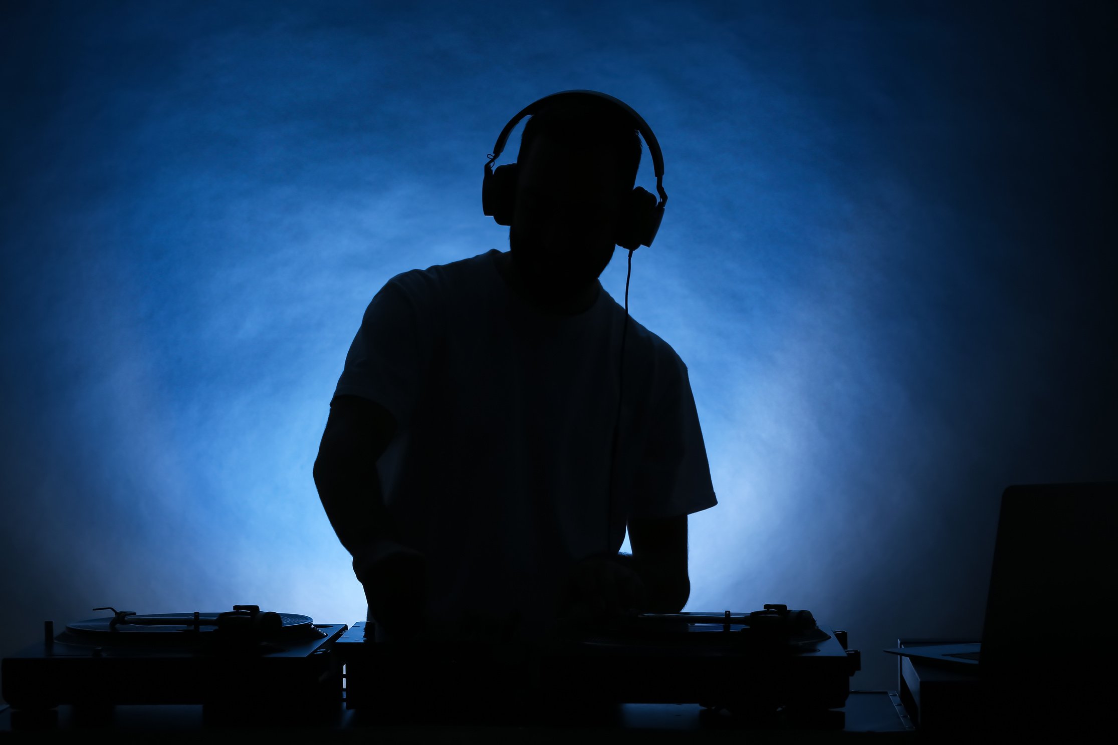 Silhouette of Male DJ Playing Music on Color Background